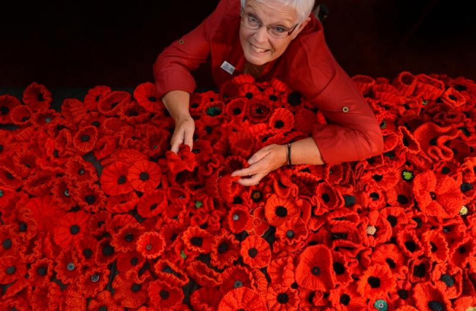 Otago Settlers Association president Susan Schweigman with some of the knitted flowers that will...
