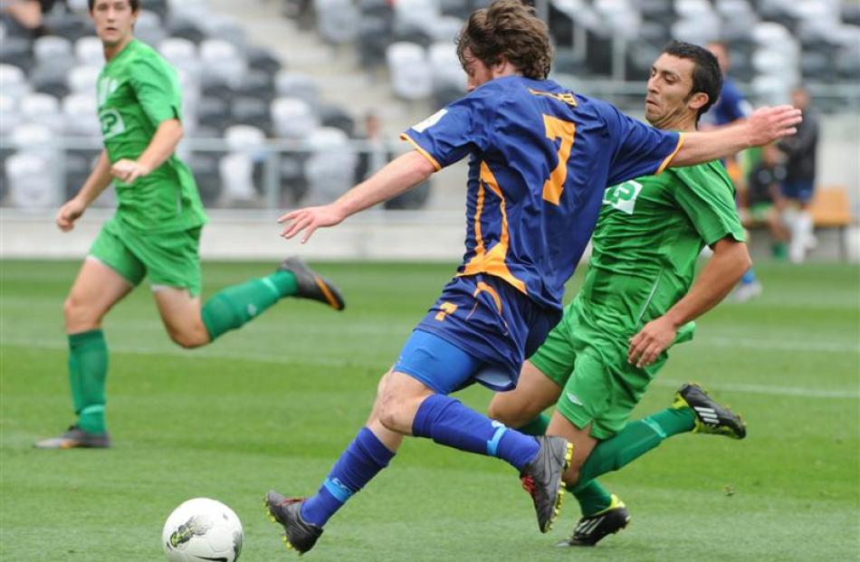 Otago United's Regan Coldicott looks to clear the ball from in front of Manawatu's Pablo Moya...