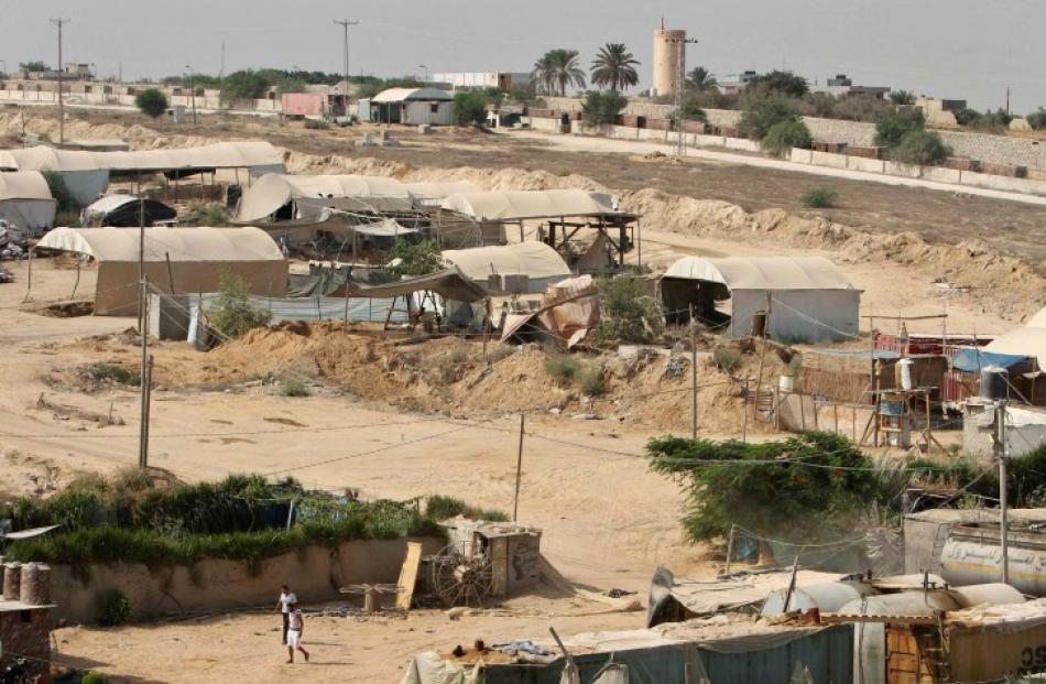 Palestinians walk near smuggling tunnels on the border between Egypt and the southern Gaza Strip,...