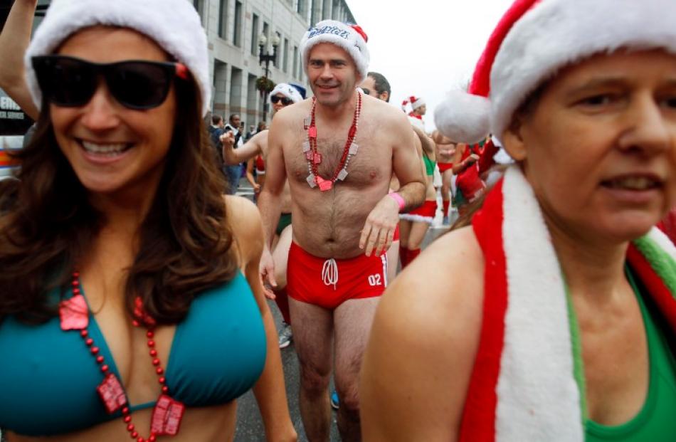 Participants leave the starting line in the annual 'Santa Speedo Run', a charity race through the...