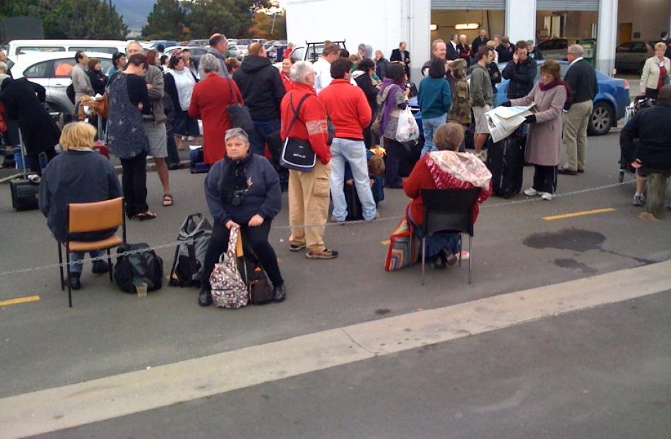 Passengers outside Dunedin Airport after they were evacuated this morning. Photo by Craig Baxter