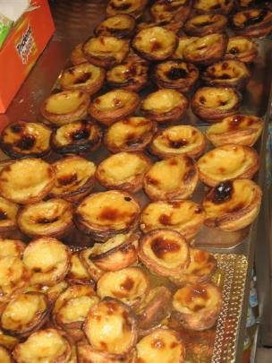 Pasteis de nata (Portuguese custard tarts) are piled high in a local bakery. Photo by Pam Jones.