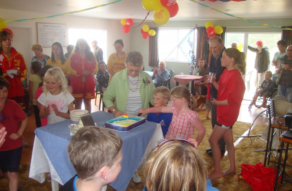 Pat Ellison (founding member of Warrington Surf Life Saving Club) cuts the cake with Roland...