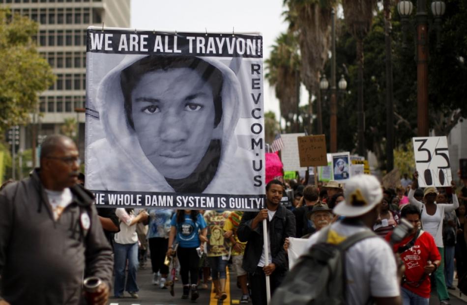 People carry a photo of Trayvon Martin during a march to protest the verdict in the George...