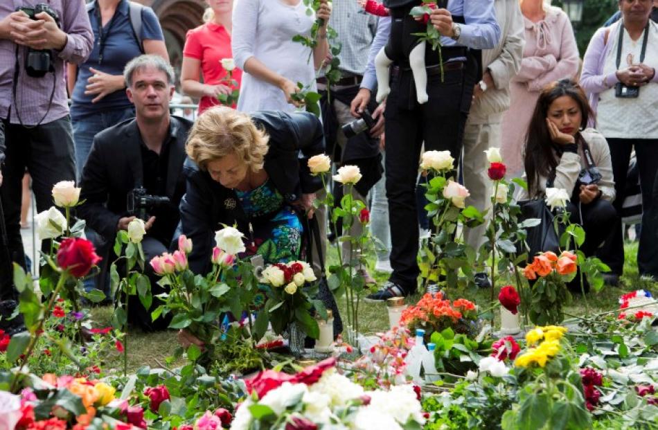 People lay flowers outside the cathedral in Oslo on the anniversary of the twin Oslo-Utoeya...
