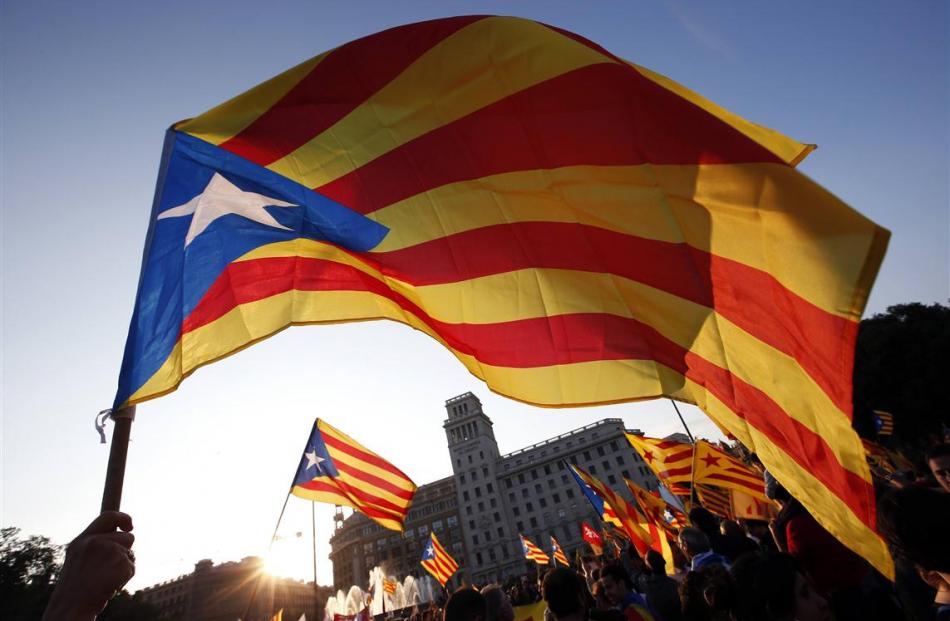 People wave Catalan separatist flags during an anti-royalist demonstration at Catalunya square in...