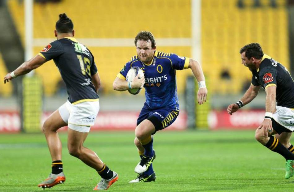 Peter Breen of Otago runs at Matt Proctor (left) and Jonny Bentley of Wellington during the ITM...