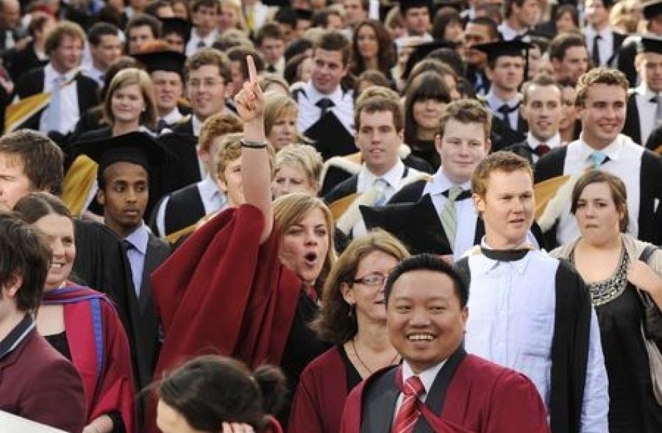 PhD candidate Andrea Valentin waves to friends during the Univeristy of Otago granduands' march...