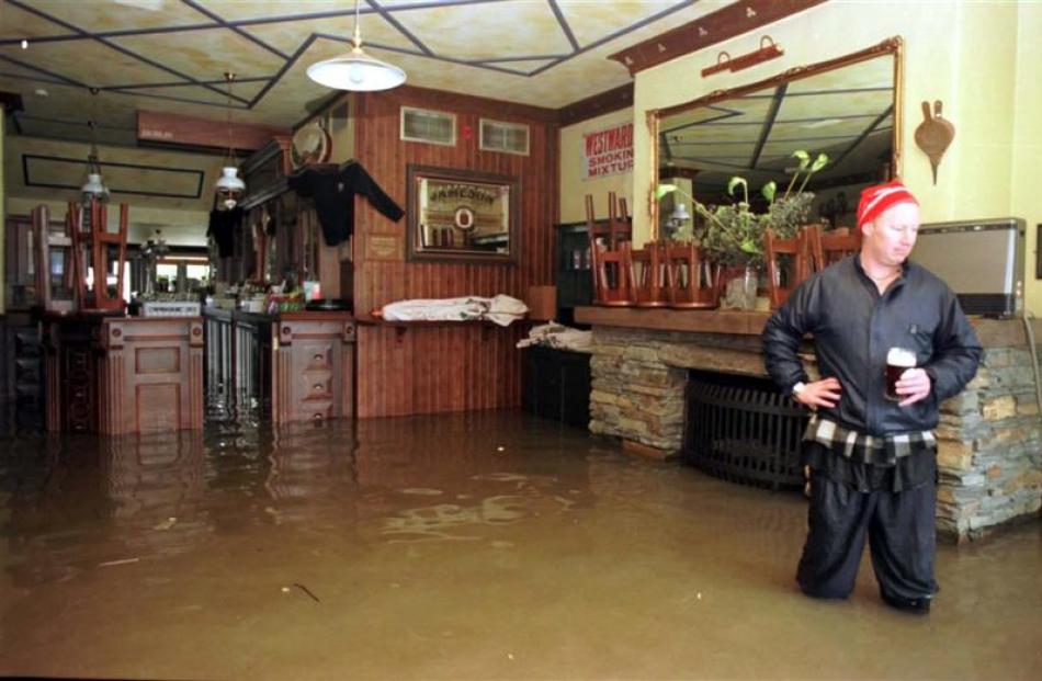 Pog Mahones bar worker Paul Murphy surveys flood damage in the Rees St bar during the 1999...