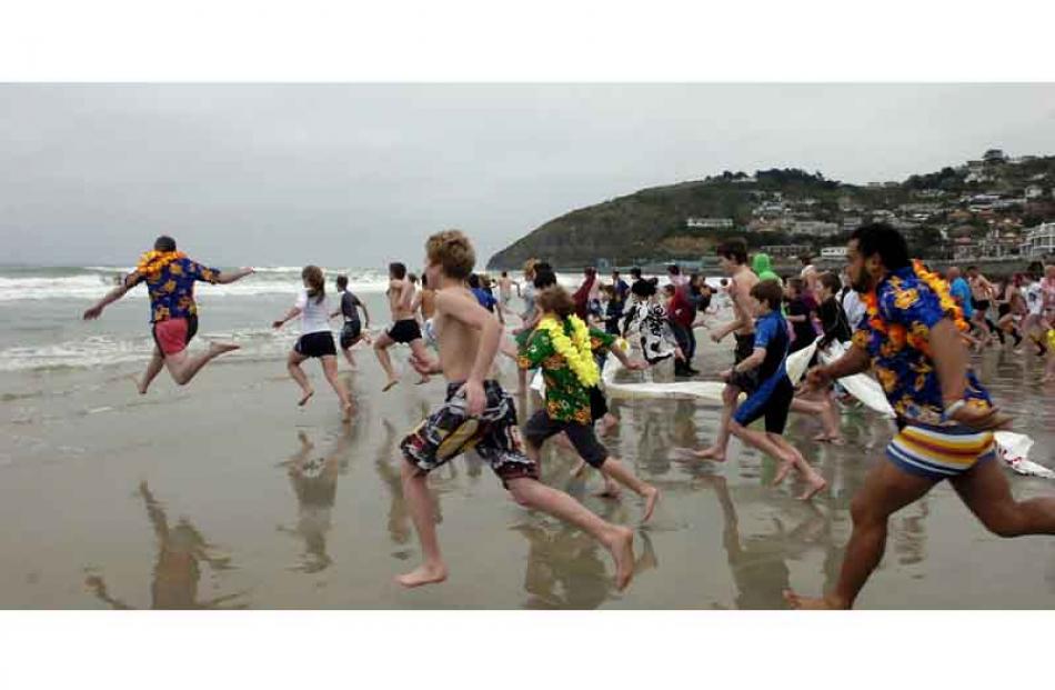 The large crowd prepare for a sudden cold snap as they enter the sea during the annual St Clair...