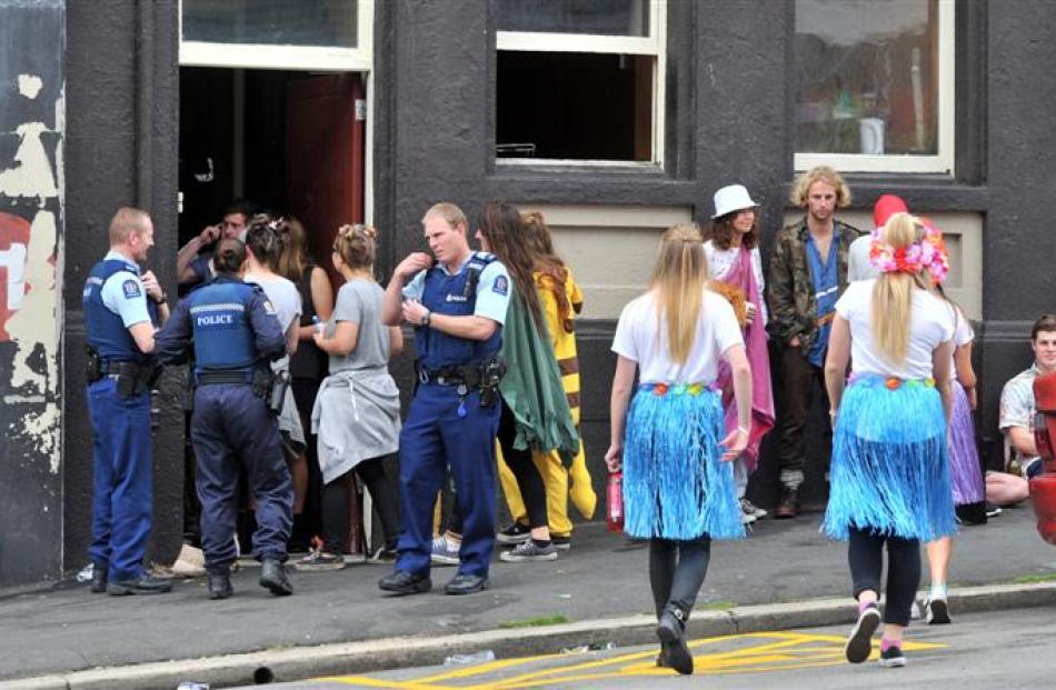 Police enter a flat party in Stafford St yesterday following reports of disorder. Photo by Linda...