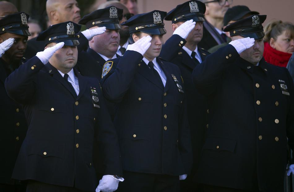 Police officers salute as the casket of NYPD officer Rafael Ramos arrives for his wake at Christ...