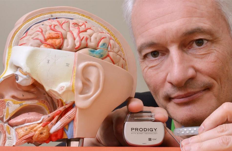 Prof Dirk De Ridder with a  brain  implant and an external activation device. Photo: Gerard O'Brien
