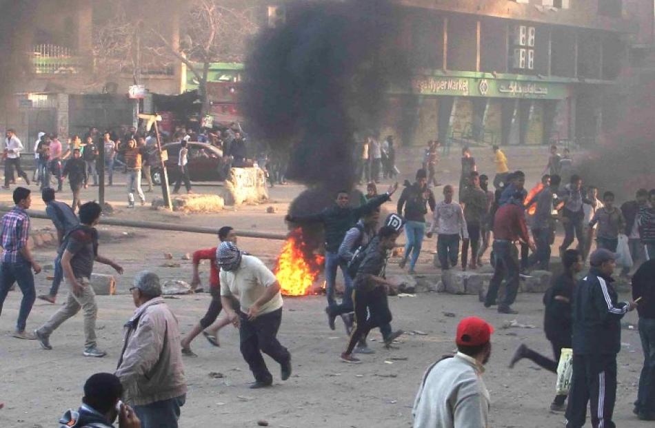 Protesters run during clashes with police in Ain Shams area east of Cairo. REUTERS/Al Youm Al...