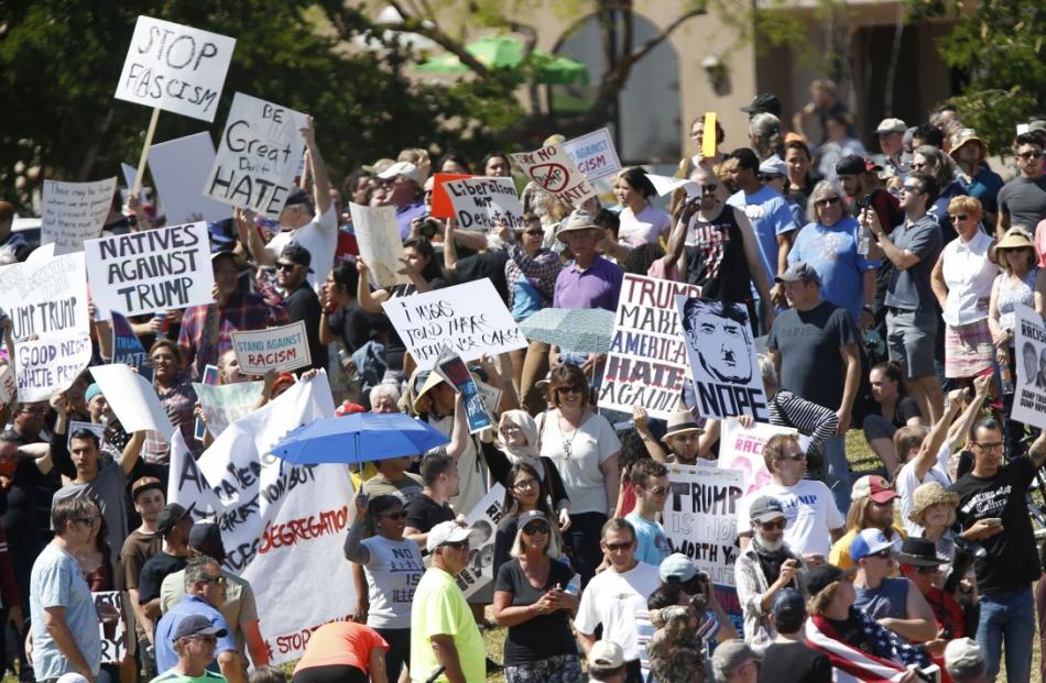 Protestors hold signs during a campaign rally by Republican U.S. presidential candidate Donald...