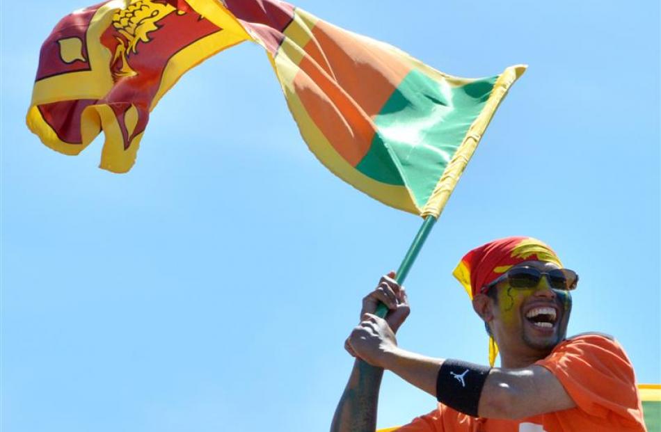 Proud supporter Shammika Rodrigo waves the Sri Lankan flag at the University Oval yesterday....