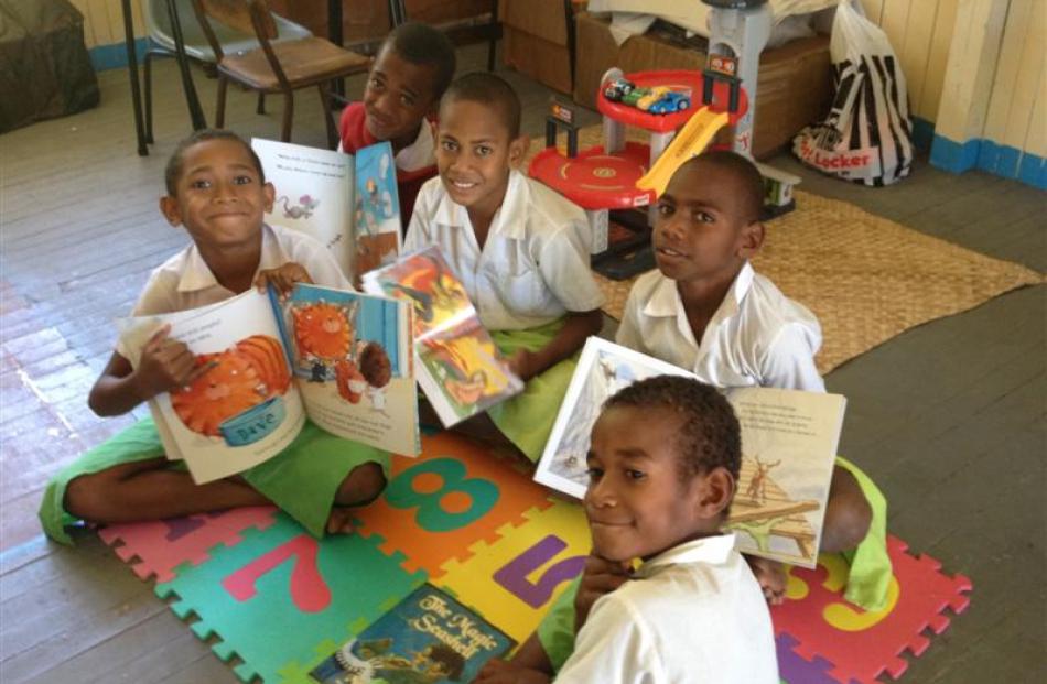 Pupils of Naviti District School with some of the books in the Otago Daily Times parcel. Photos...