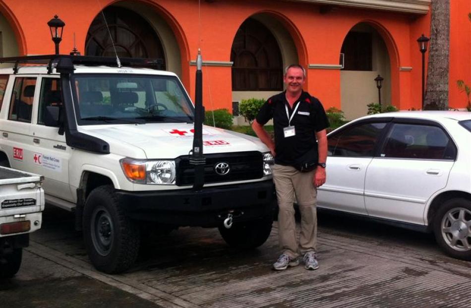 Red Cross humanitarian worker Glenn Mitchell, of Dunedin, in Ormoc on Leyte Island with one of...