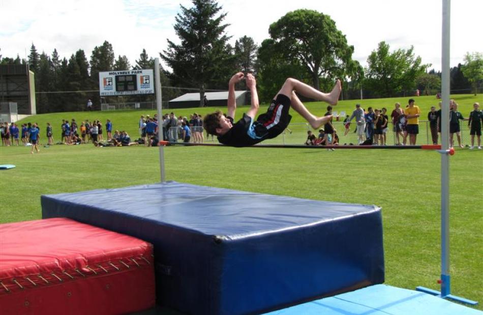 Regan Hucklebridge (13), of Cromwell College, clears the bar in the boys 13-plus high jump.
