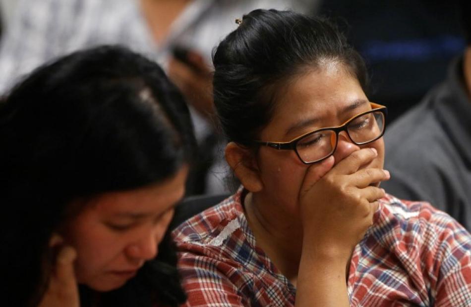 Relatives of passengers onboard AirAsia flight QZ8501 wait for news in Juanda International...