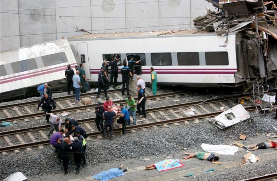 Rescue workers pull victims from a train crash near Santiago de Compostela, northwestern Spain....
