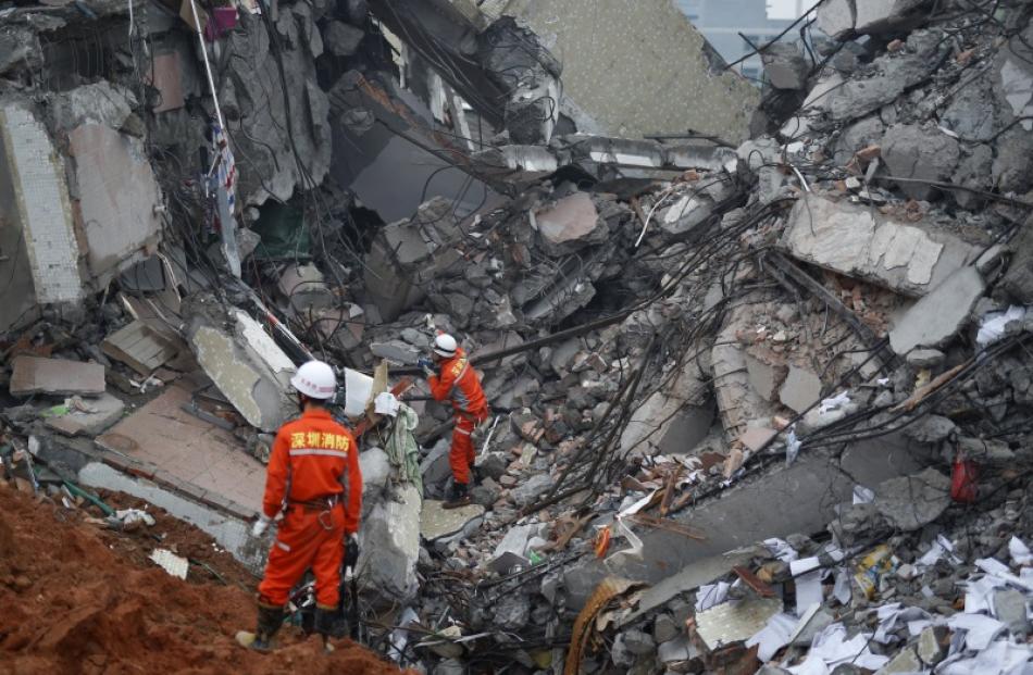 Rescue workers search for people after a landslide in china. Photo: Reuters