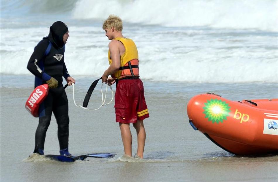 Rescued diver Sam Thomson is helped by Angus McKenzie of the St Clair Surf Club.