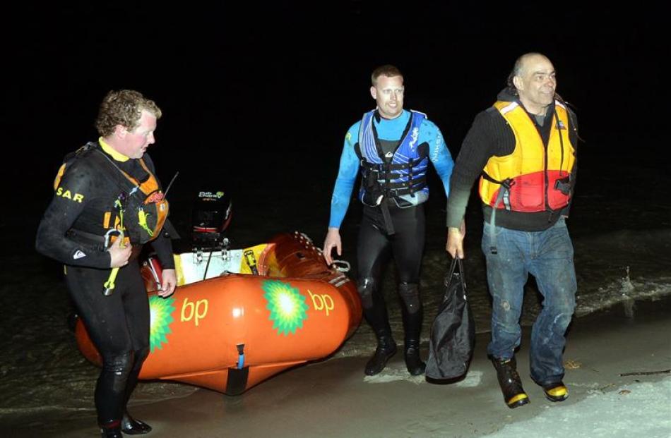 Rescued skipper Colin Webb (right) heads for high ground at Taieri Mouth last night after being...