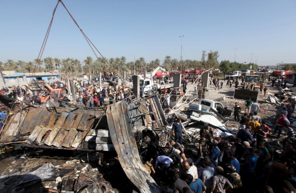 Residents gather at the site of the car bomb attack at a checkpoint in the city of Hilla. Photo:...