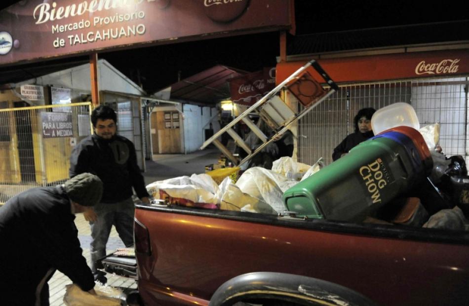 Residents take their belongings to higher ground after a Tsunami alarm at Talcahuano city, south...