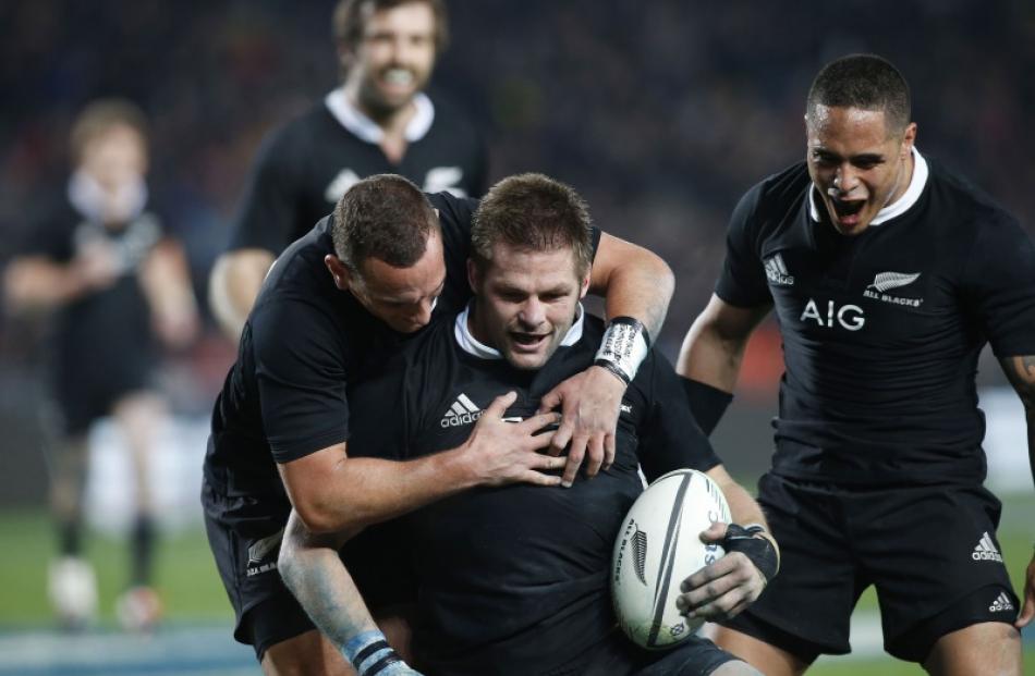 Richie McCaw, captain of New Zealand's All Blacks, scores a try against Australia's Wallabies and...
