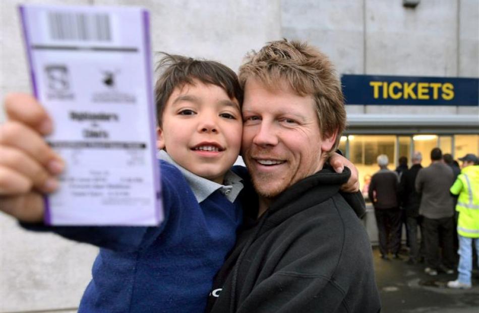 Ross Phillips and son Caius (6) hold tickets to the play-off rugby match at Forsyth Barr Stadium...