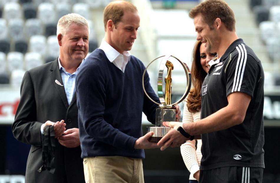 Prince William presents the IRB World Trophy to McCaw while watched by NZ Rugby chief executive...