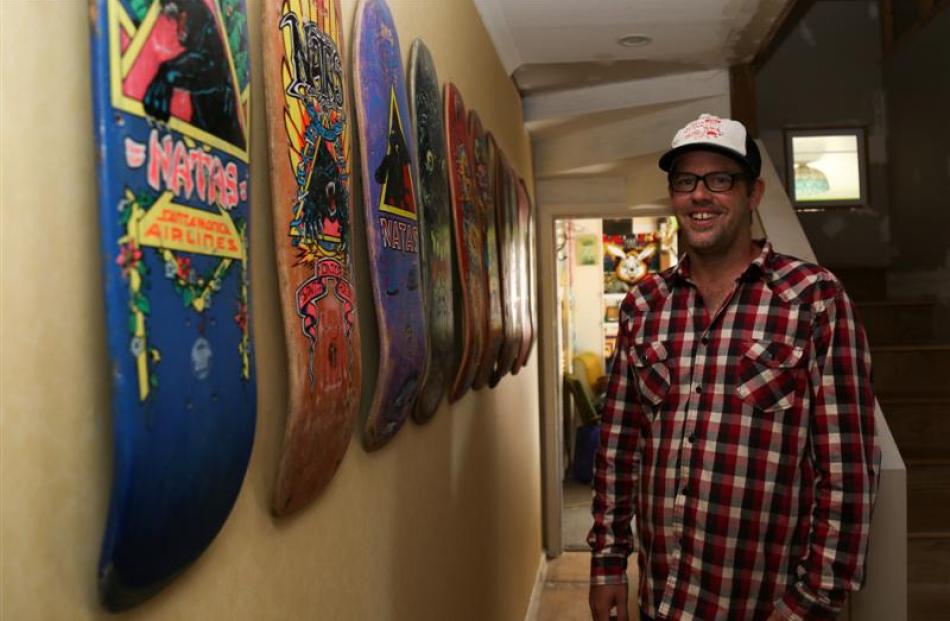 Ryan Moore stands beside his collection of vintage skateboards displayed at his Oamaru home....