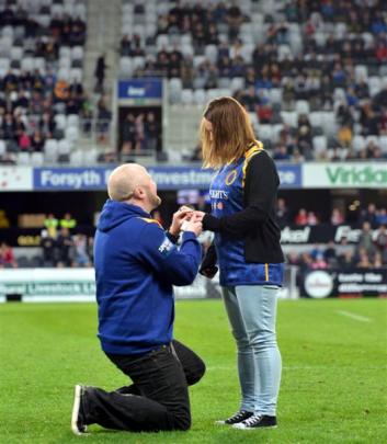 Sam Gilchrist goes down on one knee to propose to partner Ruth Jamieson at halftime during the...
