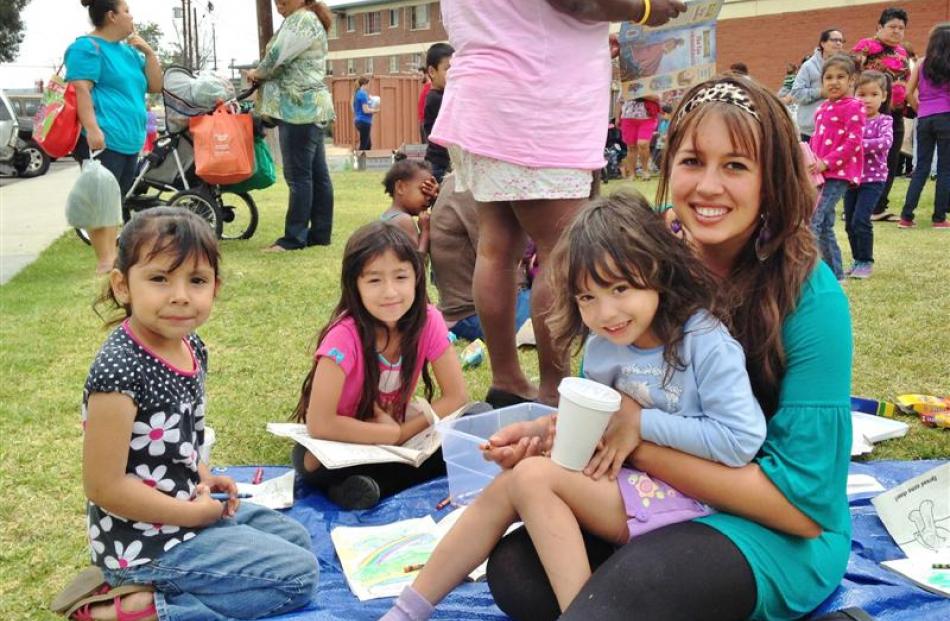 Samantha Martin (right) takes time out from her work at the Dream Center to hang out with some...