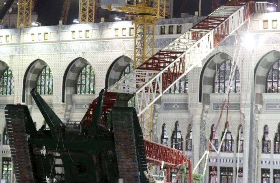 Saudi emergency crew stand near a construction crane after it crashed in the Grand Mosque in the...