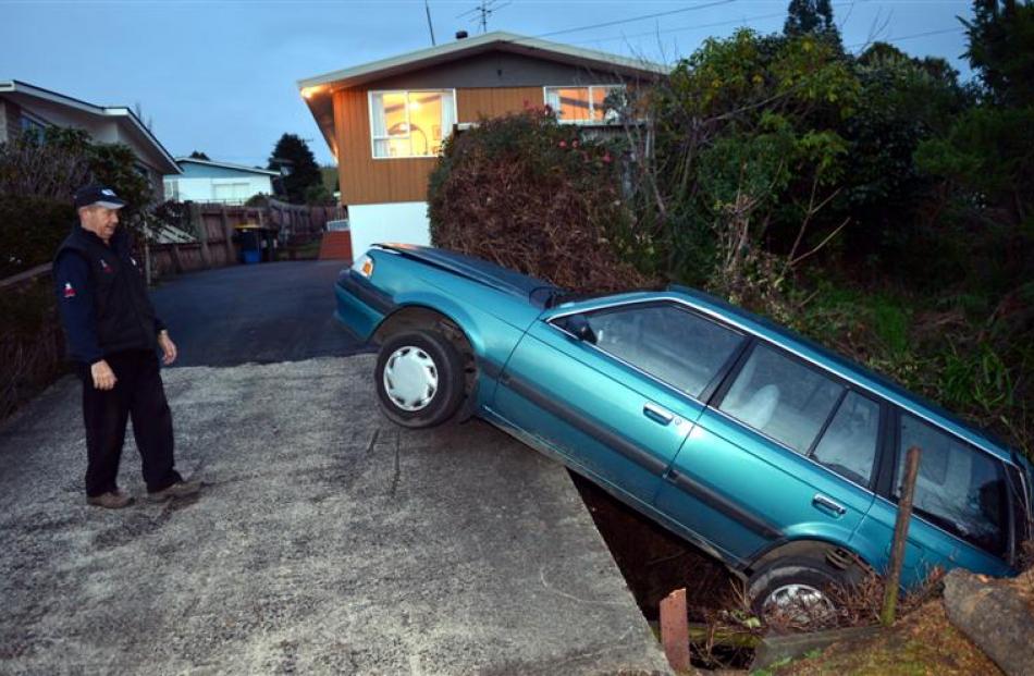 Sawyers Bay resident Russell Dawe assesses damage to his vehicle, which he reversed off his...