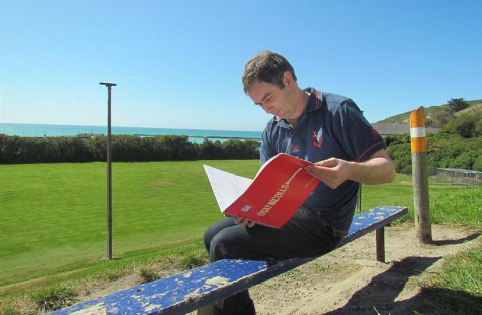 Scott Cameron checks out a scorebook at King George Park. Photo by Hayden Meikle.