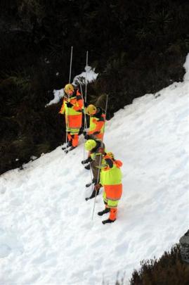 Searchers probe avalanche debris during the search for the men. The first body was found on...