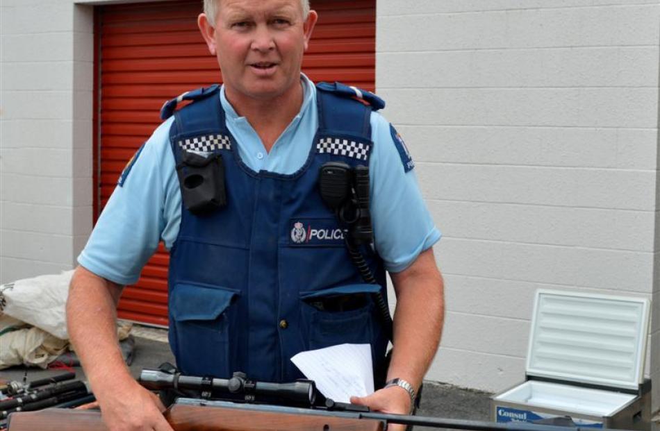 Senior Constable Murray Hewitson, of Owaka, with the BSA air rifle found with  property recovered...