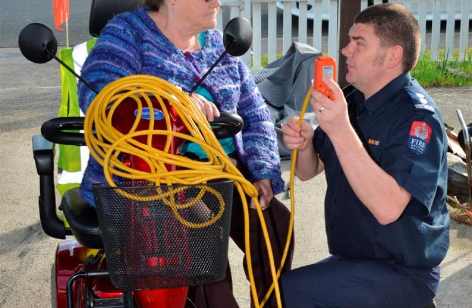 Senior station officer Scott Lindsay explains how to safely charge a mobility scooter to Eleanor...