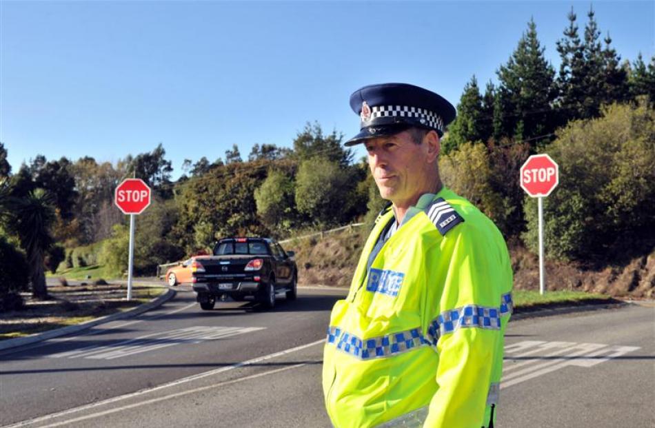 Sergeant Warren Kemp, of Dunedin International Airport police, keeps an eye on motorists as they...