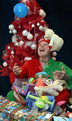 Shane Waldron is busy wrapping Christmas presents to be delivered to less fortunate families on...