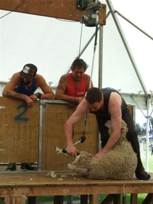 Shearer Joe Maher gives a demonstration of speed shearing, watched by Clinton Te Kani (left) and...