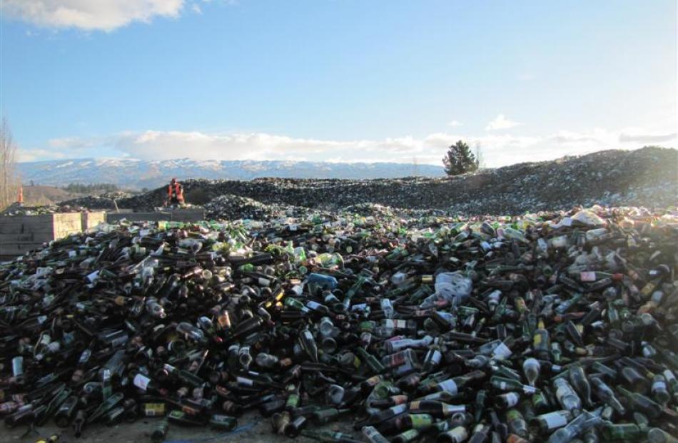 Sione Ah Mann sorts through the clean glass, recently bought in by the recycling truck. In the...