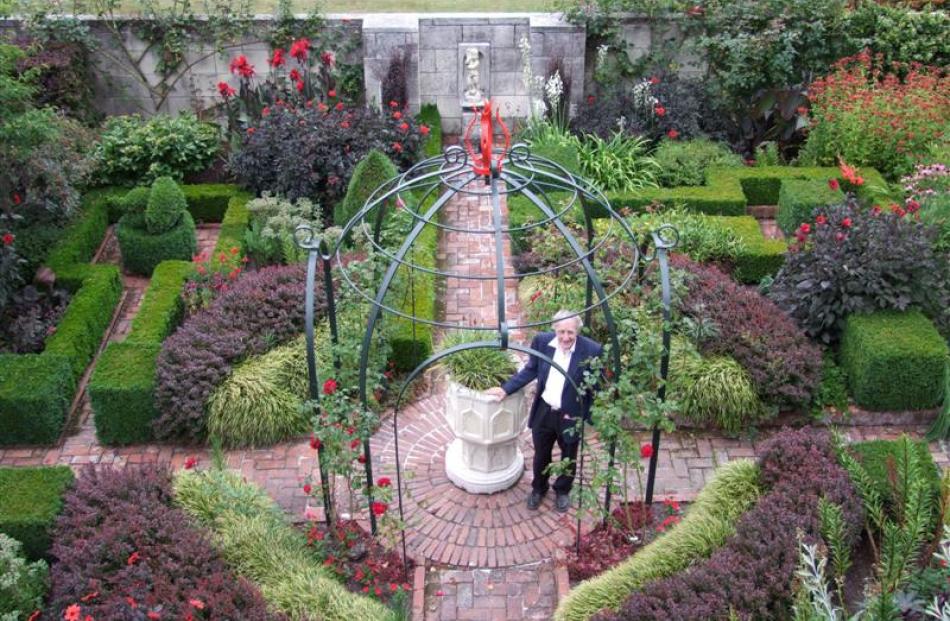 Sir Miles stands by an old font in the centre of the formal Red Garden. The use of red was echoed...