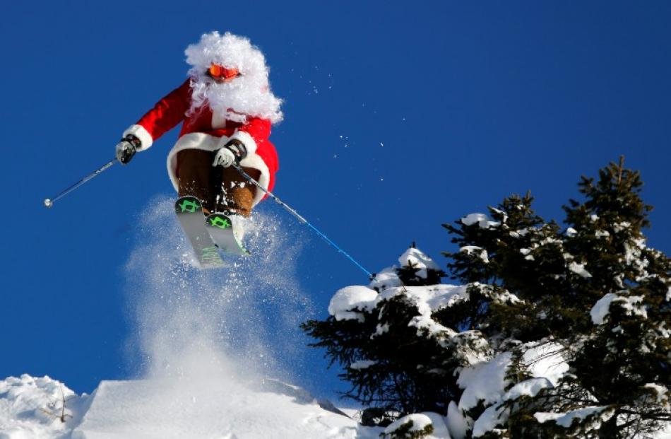 Ski teacher Alberto Ronchi makes a jump dressed as Santa Claus in Madonna di Campiglio in...