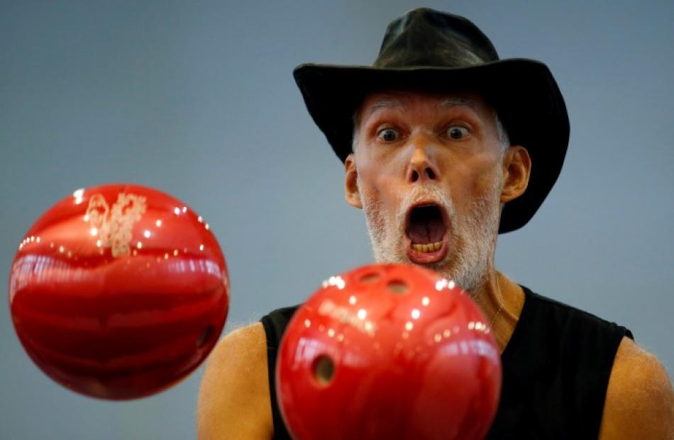Slovakia's Milan Roskopf juggles with bowling balls as he tries to break a record during the...