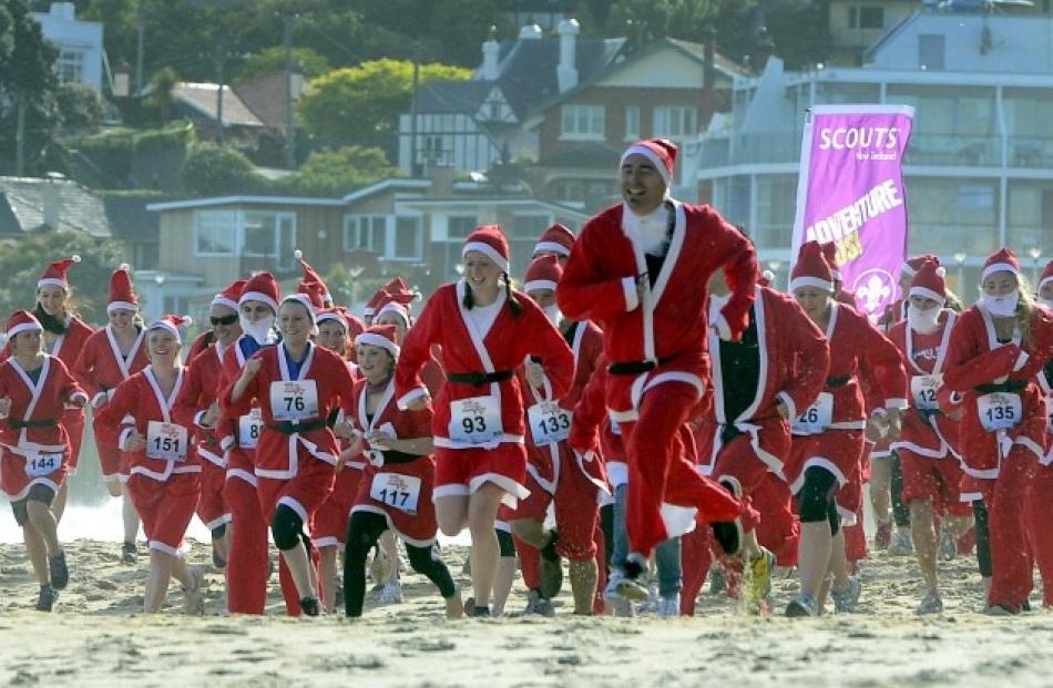 Some of the 152 participants take part in Great KidsCan Santa Run on St Clair beach in Dunedin...